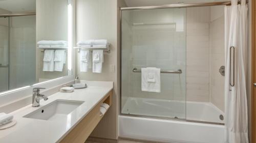 a white bathroom with a shower and a sink at Hotel Noto Marina Scirocco & SPA in Noto Marina