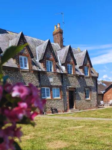 an old stone house with a dog in front of it at Rural Retreat near West Wittering Beach! Dog Friendly & Free Parking - Ideal Weekend Getaway! Chichester Holiday Properties in Donnington