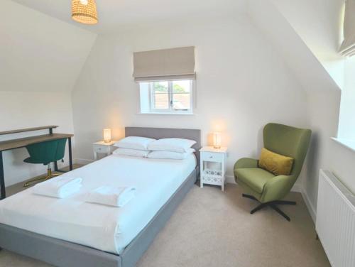 a bedroom with a bed and a green chair at Rural Retreat near West Wittering Beach! Dog Friendly & Free Parking - Ideal Weekend Getaway! Chichester Holiday Properties in Donnington