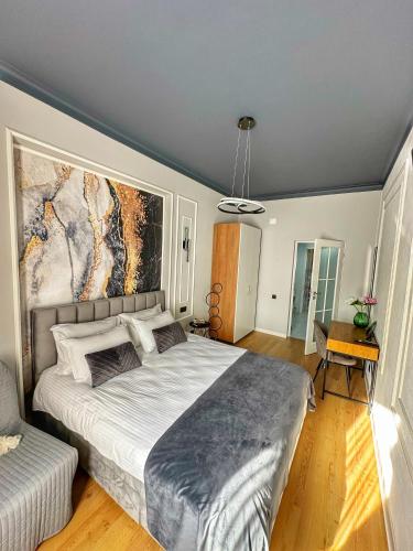 a bedroom with a large bed with a painting on the wall at Euphoria Apartments in Beiuş