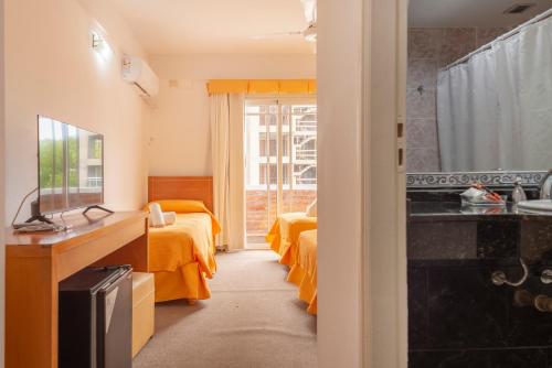 a hotel room with two beds and a sink at Belmar in Villa Gesell
