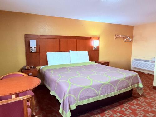 a hotel room with a large bed and a table at Aloha Inn McAllen Airport near Medical center Tx in McAllen