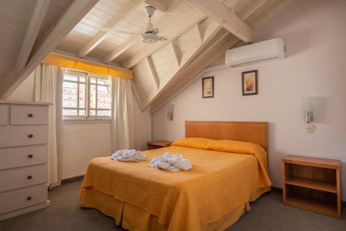 a bedroom with a bed with towels on it at Belmar in Villa Gesell