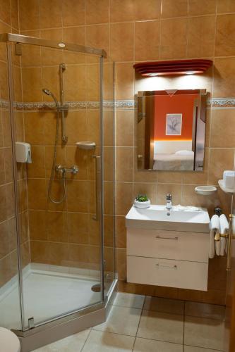 a bathroom with a shower and a sink at Hotel Penta Lux in Tata