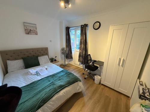 a bedroom with a bed and a clock on the wall at Double Room - Central Dartford - Free Parking in Dartford