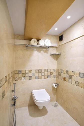a bathroom with a toilet and a sink at Glitz Saineel Executive Near Juhu Beach in Mumbai