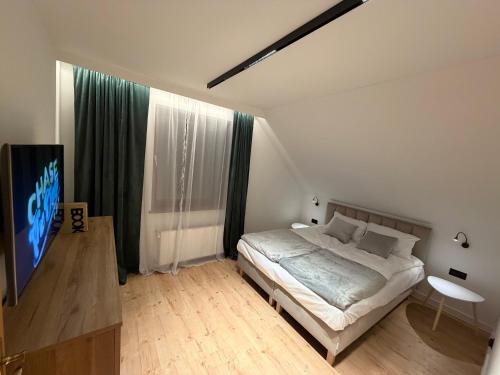 a bedroom with a bed and a flat screen tv at Klakierówka in Piechowice
