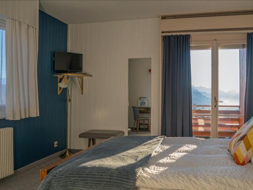 a bedroom with a bed and a view of the ocean at Hôtel historique Chez Elsy - Crans-Sapins in Crans-Montana