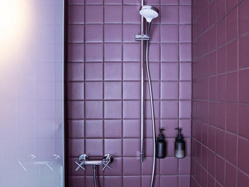 a shower with purple tiles in a bathroom at Hôtel historique Chez Elsy - Crans-Sapins in Crans-Montana