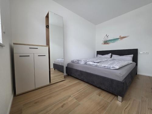 a bedroom with a bed and a mirror at Zippel`s Fewo M14 in Bad Buchau