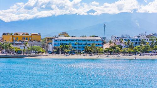a view of a beach with buildings and the water at Panamerican Hostel in Santa Marta
