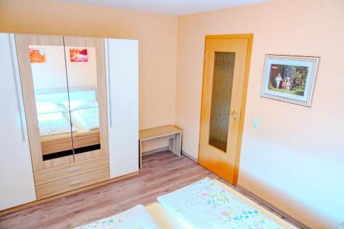 a room with a bedroom with a bed and a mirror at Ferienwohnung 2 "Zum Feld" auf dem Alpakahof in Bernstadt