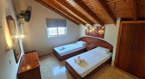 a room with two beds and a table in it at Kathrin apartments in Ipsos