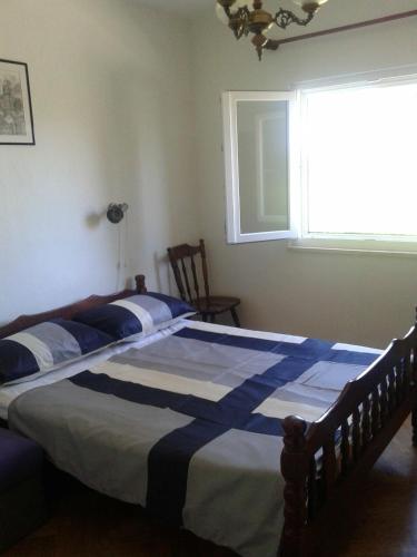 a bedroom with a bed with a blue and white comforter at Apartment Dora in Splitska