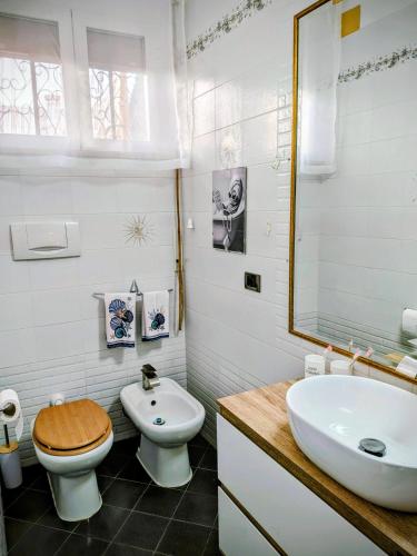 a white bathroom with a toilet and a sink at In Via Capri 1991 APARTMENT in Follonica