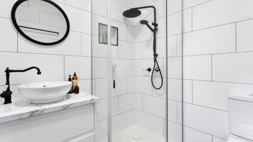 a bathroom with a shower with a sink and a mirror at Waves on Rye in Rye