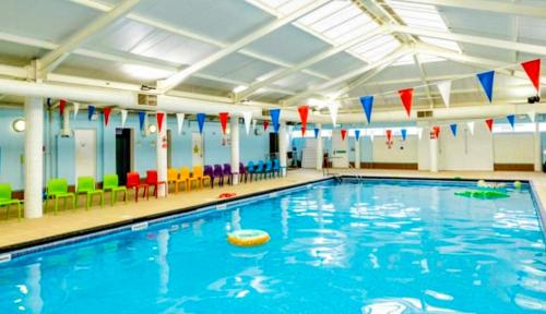 a large swimming pool in a gym with colorful chairs at SummerBreeze Retreat in Hartley