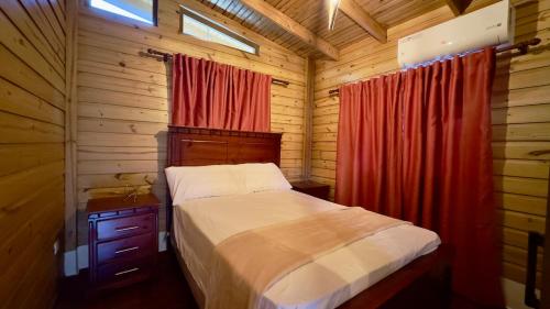 a bedroom with a bed in a wooden cabin at Riverfront Paradise Villa River front Villa in Jarabacoa