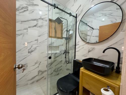 a bathroom with a shower with a mirror and a sink at Riverfront Paradise Villa River front Villa in Jarabacoa