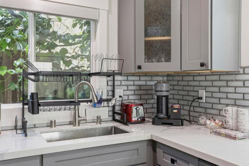 a kitchen counter with a sink and a window at Angie Oasis Yard, Loft & Stocked Kitchen in San Ramon