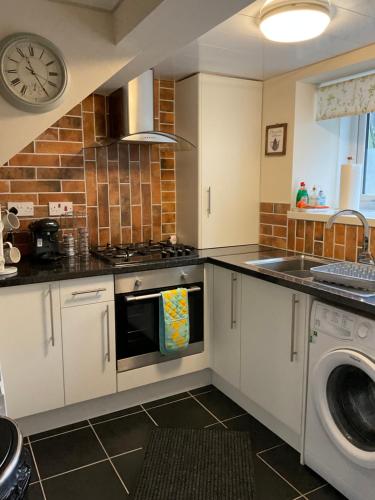 a kitchen with a stove and a dishwasher at Meadow Cottage in Crieff