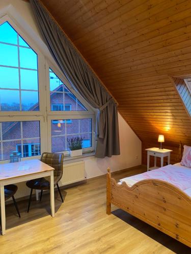 a bedroom with a bed and a table and a window at Ferienhof Kröger in Bielefeld
