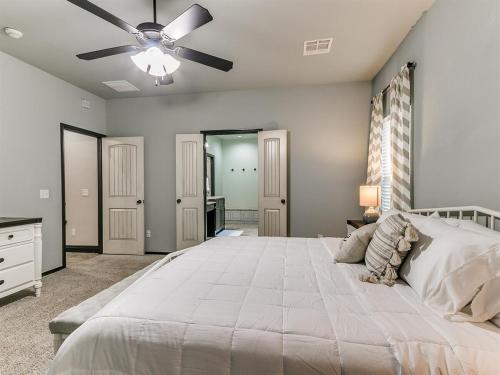 a bedroom with a large bed with a ceiling fan at Spacious Deer Creek Home with Study and Yard in Edmond
