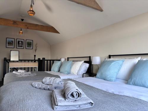 two beds with towels on them in a bedroom at 12 Banc Pendre in Kidwelly