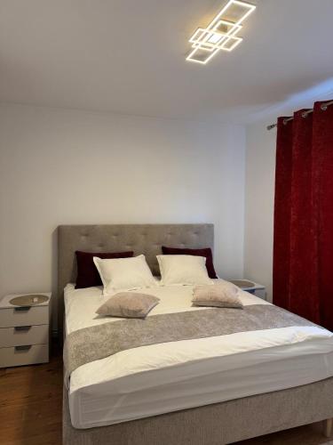 a bedroom with a large bed with a red curtain at Luxury Comfort Home in Anklam