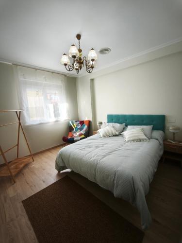 a bedroom with a large bed with a chandelier at Aires do Masma in Foz