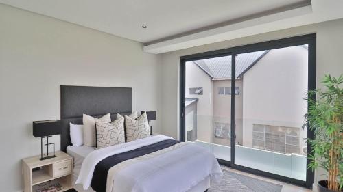 a bedroom with a large bed and a large window at Pops lifestyle in Sandton