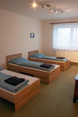 a room with three beds in a room at Apartmán se společným bazénem Zlonice in Zlonice