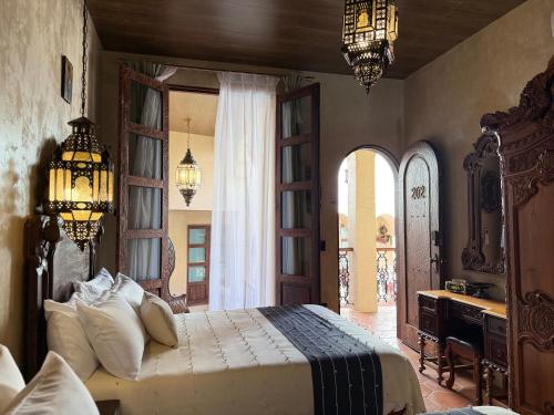 a bedroom with a bed and a desk and chandeliers at Riad Xula Boutique Hotel in Puerto Peñasco