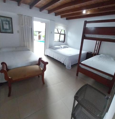 a bedroom with two beds and a bunk bed at Hotel Piedra del Mar in Puerto López