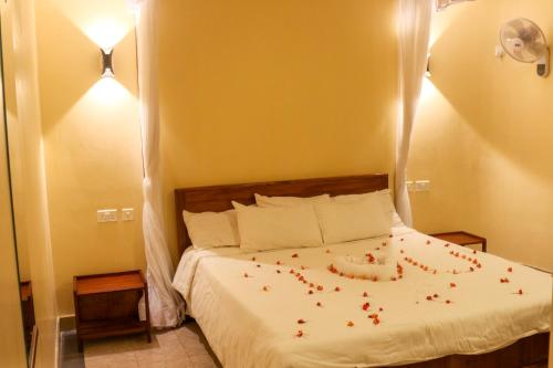 a bedroom with a bed with red flowers on it at Paran Amboseli Resort in Kimana