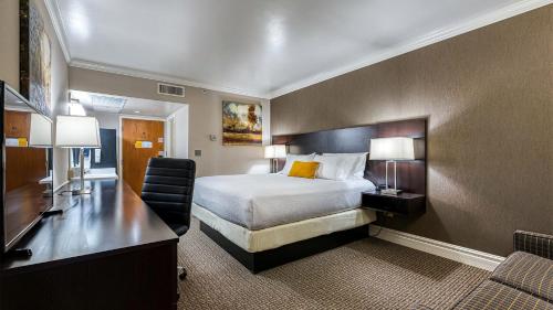a hotel room with a bed and a desk at University Inn in Logan