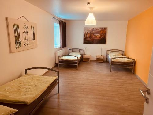 a room with three beds and a window at StayHere24 Große Monteur- und Ferienwohnung am Auenwald in Schkeuditz