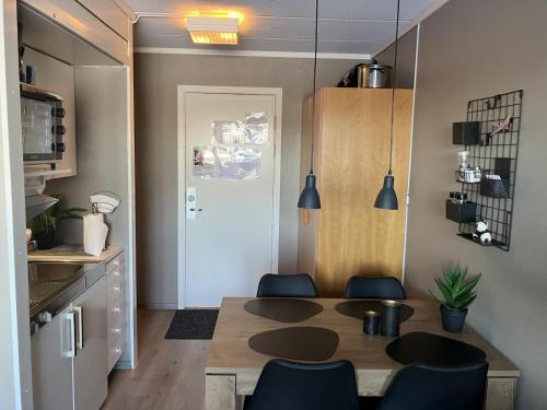 a kitchen with a table and chairs in a room at Apartment in Gautefall in Drangedal