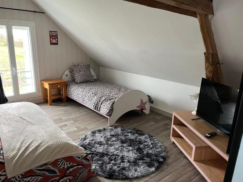a bedroom with a bed and a tv and a table at Logement indépendant à la campagne proche du Pôle européen du Cheval et Circuit des 24h du Mans in Courceboeufs