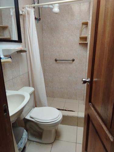 a bathroom with a toilet and a sink at Hotel Piedra del Mar in Puerto López