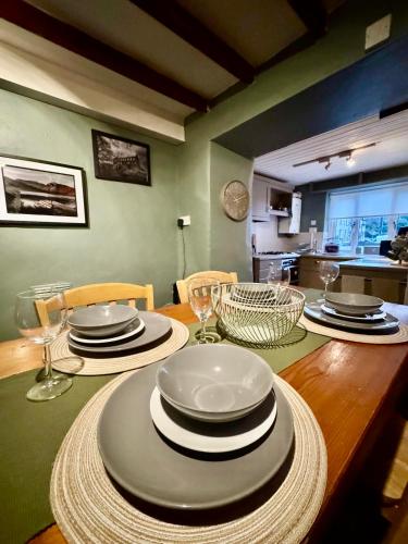 a dining room table with plates and wine glasses at House in Llanberis in Llanberis