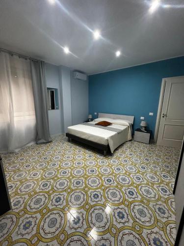 a bedroom with a bed and a blue wall at Thalore room e apartments in Amantea