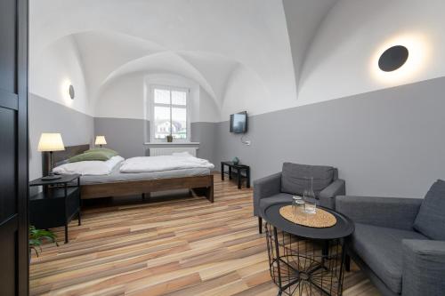 a living room with a couch and a bed at Penzion, restaurant Gloria in Chrastava