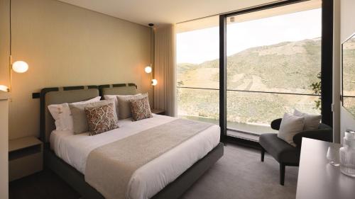 a bedroom with a bed and a large window at Quinta Vale de Lobos in Folgosa