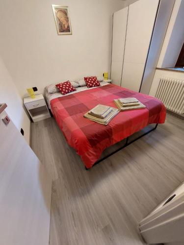 a bedroom with a bed with a red blanket at Pres du Chateau in Châtillon