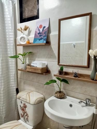 a bathroom with a sink and a toilet and a mirror at Langga Crib in Lapu Lapu City