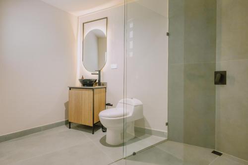 a bathroom with a toilet and a mirror at Casa Palma in Medellín