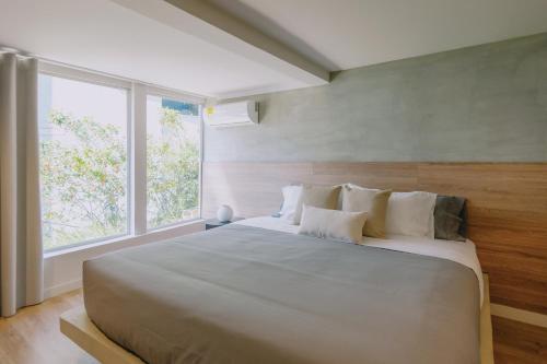 a bedroom with a large white bed with a window at Casa Palma in Medellín