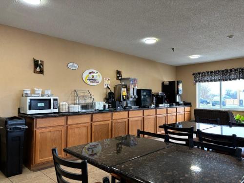 a kitchen with a table and a counter with a microwave at Super 8 by Wyndham Greenville in Greenville