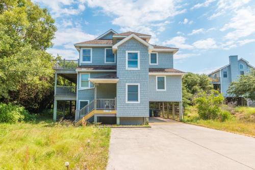 a blue house with a driveway at 3944 - Carolina Escape in Duck